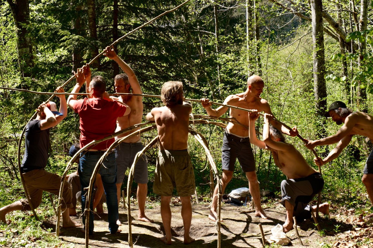 Eine Gruppe errichtet gemeinsam eine Schwitzhütte.